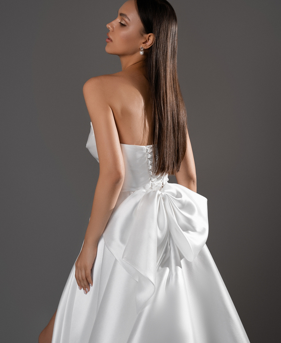 Лаконичное свадебное платье с разрезом и бантом фото