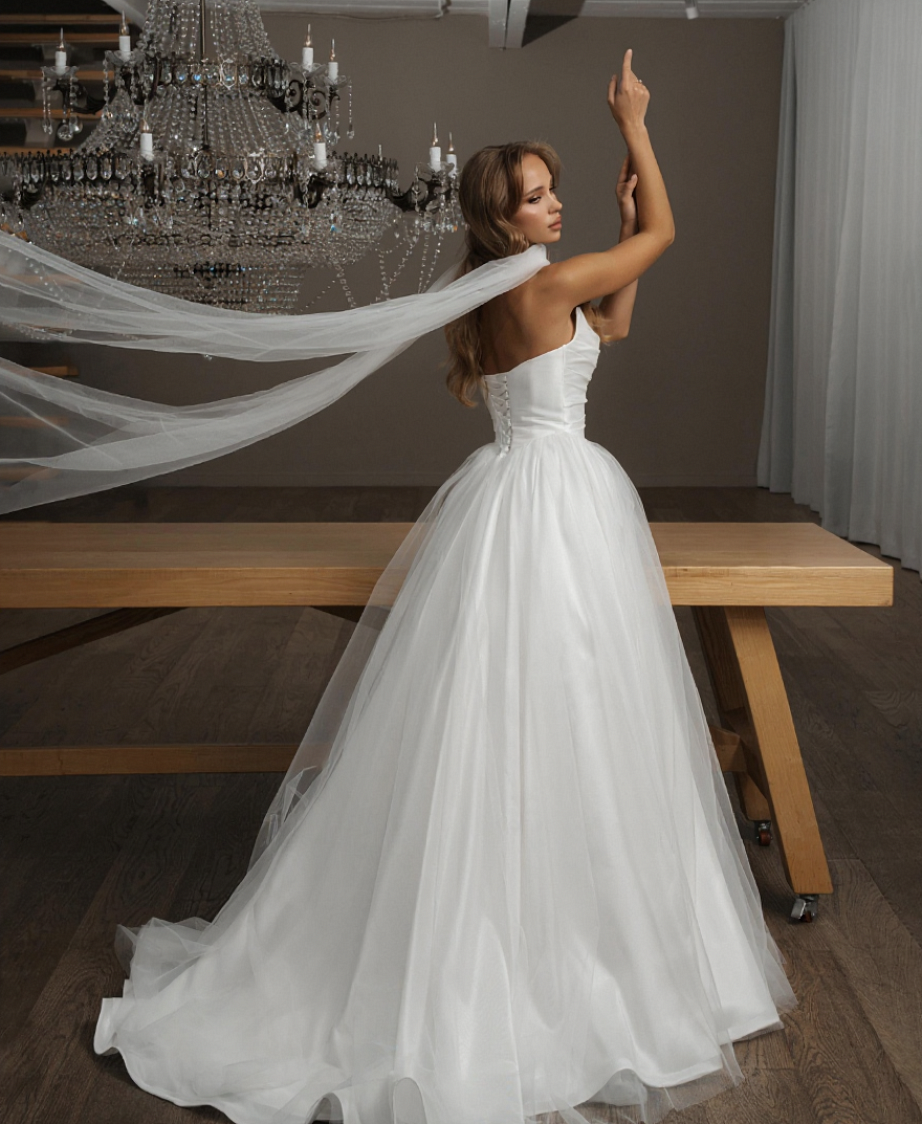 Трендовое платье с заострённой формой корсета, выполненное из благородной лёгкой ткани с деликатным блеском фото