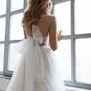 Свадебное платье на тонких бретелях с воланами на юбке фото