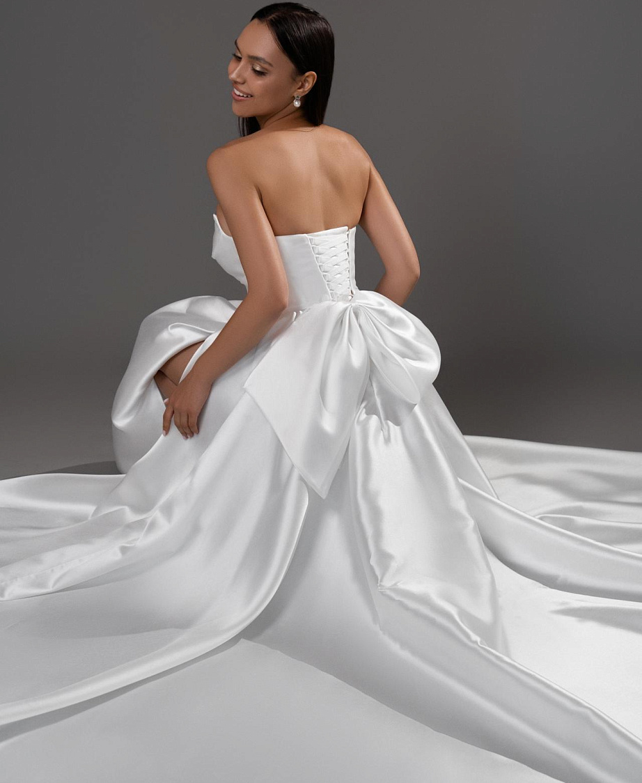 Лаконичное свадебное платье с разрезом и бантом фото