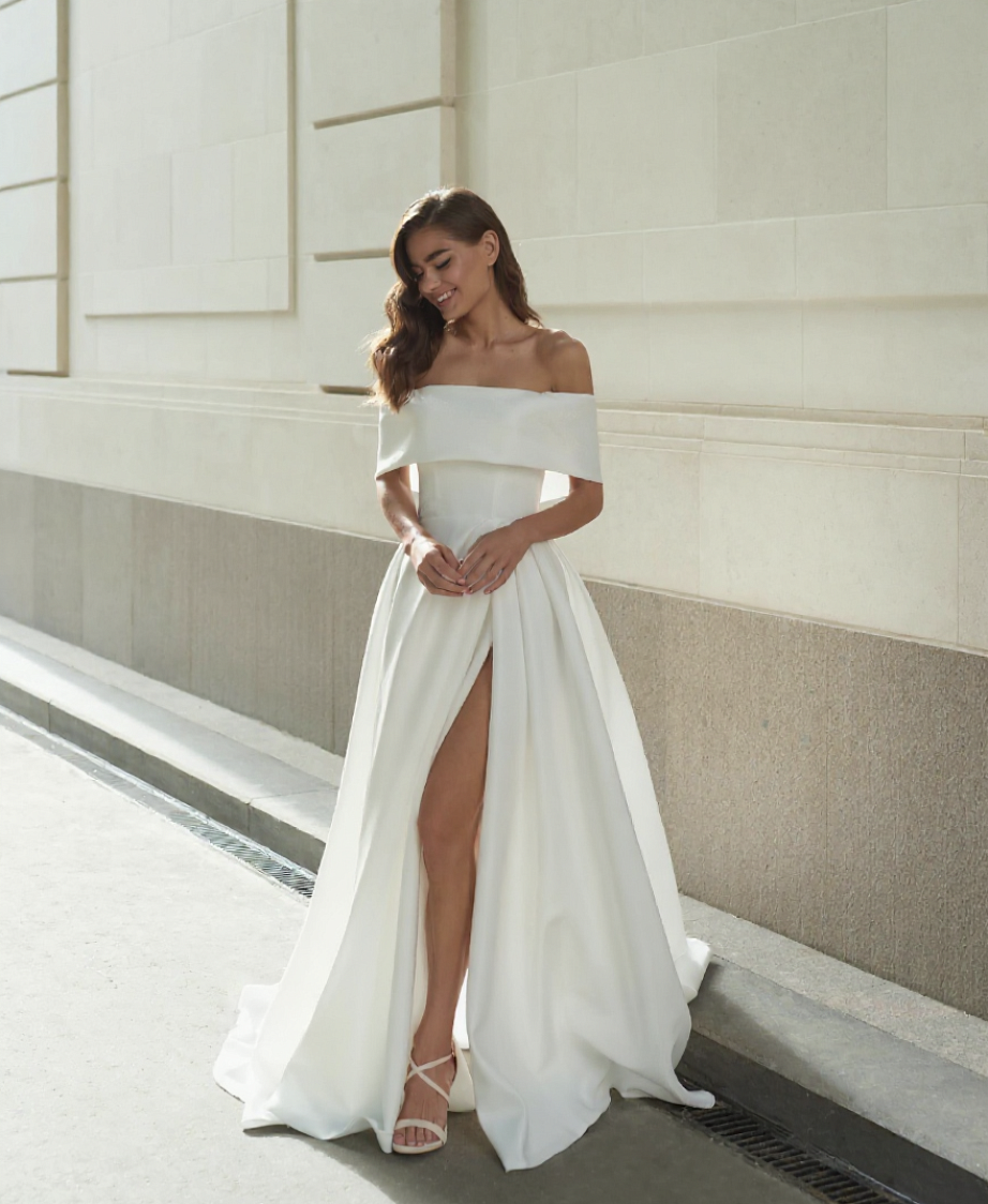 Стильное свадебное платье с открытыми плечами и эффектным разрезом но ноге фото